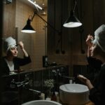 femme appliquant une crème de nuit devant son miroir salle de bain