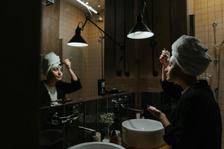femme appliquant une crème de nuit devant son miroir salle de bain