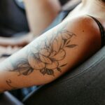 Femme montrant un tatouage floral élégant sur l'avant-bras droit