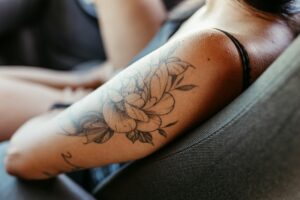Femme montrant un tatouage floral élégant sur l'avant-bras droit