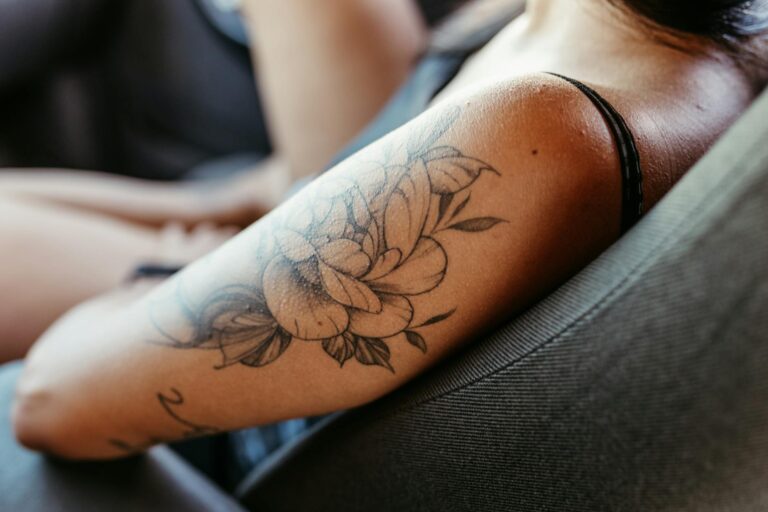 Femme montrant un tatouage floral élégant sur l'avant-bras droit