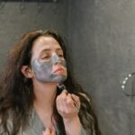 femme appliquant un masque hydratant blanc sur son visage, rituel beauté