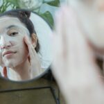femme appliquant un masque tissu blanc sur son visage soins beauté