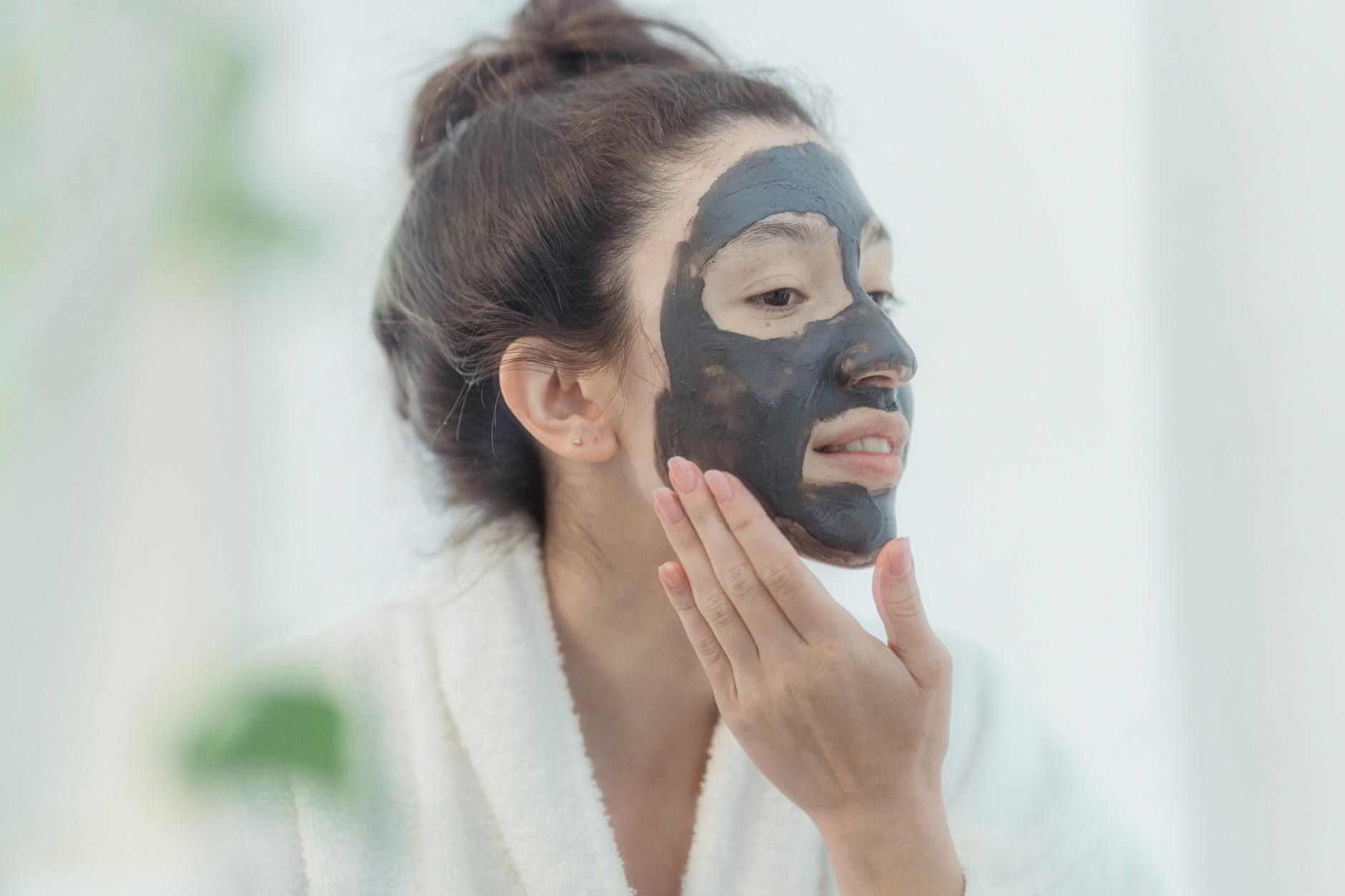 Plusieurs masques visage colorés disposés sur une tablette en bois clair, ambiance soin beauté naturel