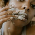 femme appliquant un masque naturel maison sur son visage avec les mains