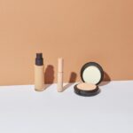 Rangée de produits cosmétiques colorés sur fond blanc épuré studio beauté