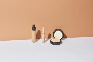 Rangée de produits cosmétiques colorés sur fond blanc épuré studio beauté