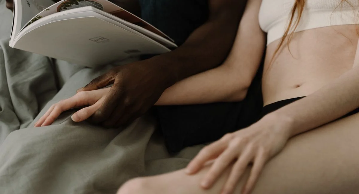 Deux mains enlacées sur des draps froissés après l'orgasme, ambiance douce