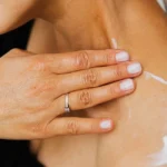 Femme applique un masque corps nuit Rituals dans une chambre apaisée