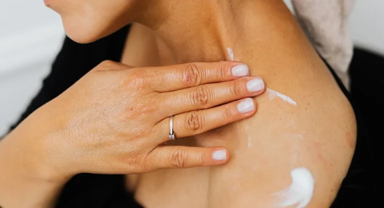 Femme applique un masque corps nuit Rituals dans une chambre apaisée