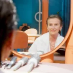 Femme devant miroir examinant quelques cheveux blancs repigmentés